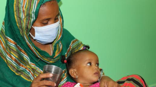 Hawa dans les bras de la mère. Elle prend sa ration de Plumpy Nut. - ©UNICEF/Djibouti/2020/Oulmi