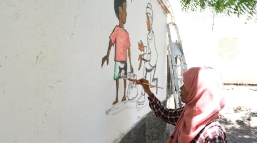 Dessins illustrant différentes thématiques migratoires sur les murs de Caritas réalisés par Lina 